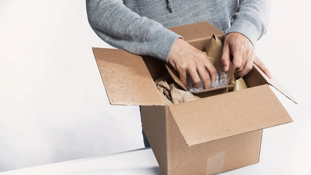 Young man preparing a package for fulfillment.