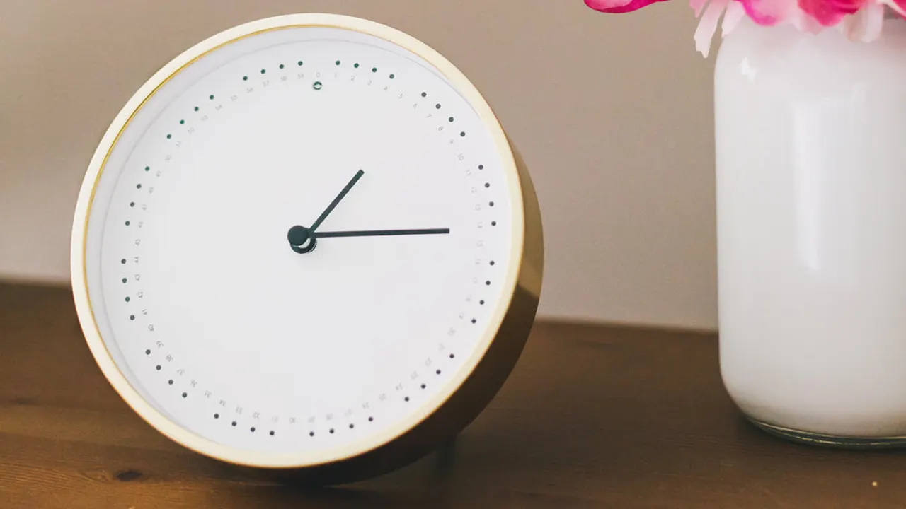 Clock and flowers on side table.