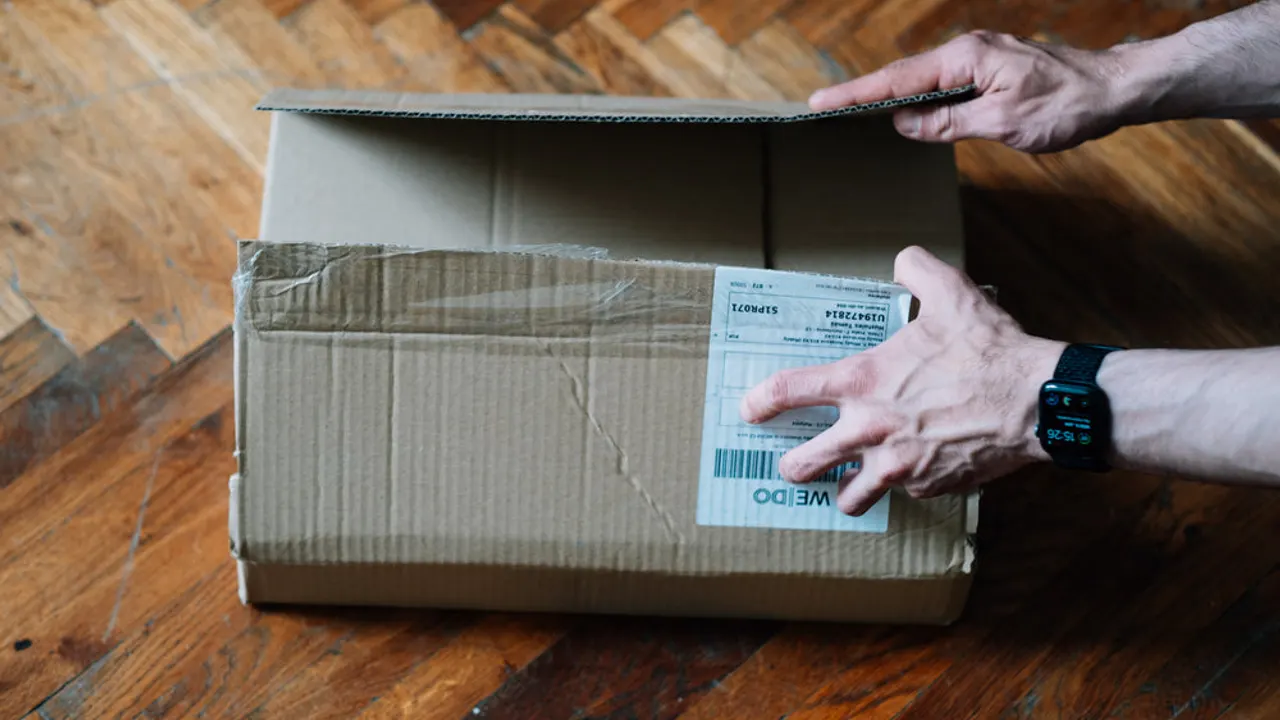 Top view of hands ready to open a cardboard box.