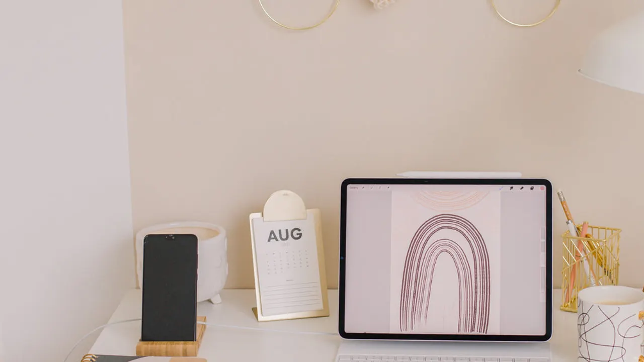Laptop on a the white desk of a home office.