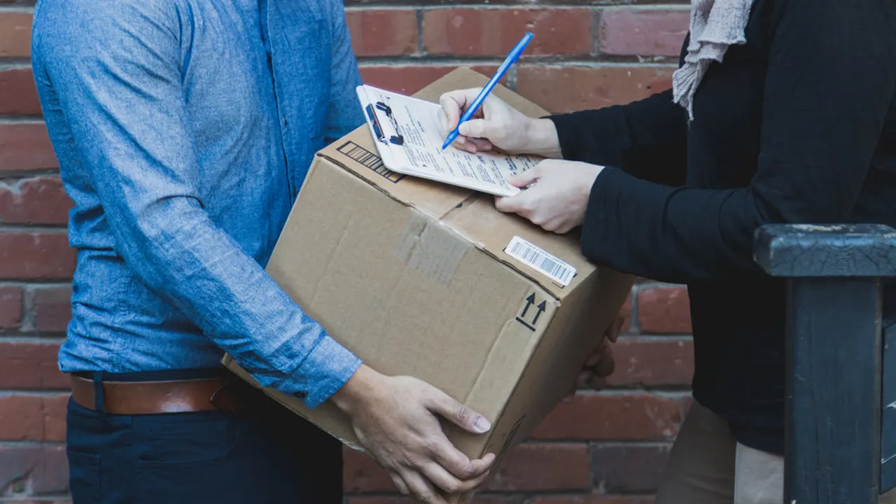 Man signing for shipping box.